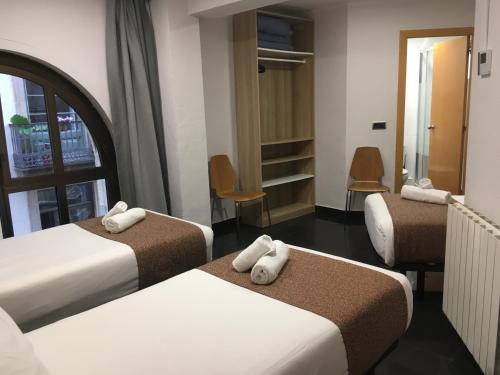Ένα ή περισσότερα κρεβάτια σε δωμάτιο στο Hostal Levante Barcelona