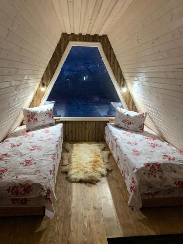 two beds in a room with a window at VIP-Domyk in Rakhiv