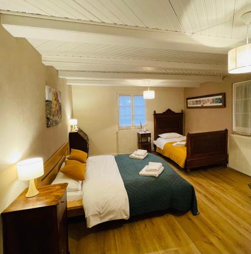 - une chambre avec 2 lits, une table et des lampes dans l'établissement La Ferme de Madeleine, à Fessenheim-le-Bas