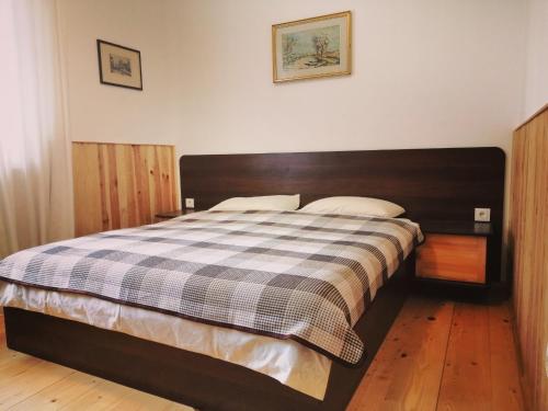 a bedroom with a large bed with a checkered blanket at apartments BS in Truskavets