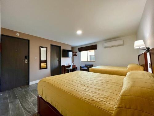 a hotel room with two beds and a desk at Neo Business Hotel in Culiacán