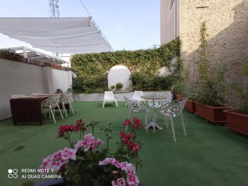 a patio with a table and chairs and flowers at B&B Palazzo Bianchi in Parma