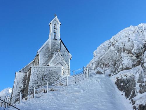 an old church on top of a snow covered mountain at Landhaus Renata - Wendelstein in Bayrischzell