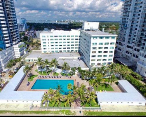 an aerial view of a building with a pool and palm trees at CASABLANCA -Kitchen, Pool, Beach- in Miami Beach