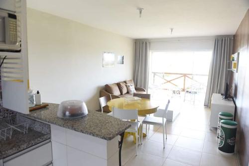 a kitchen and living room with a table and a dining room at Apartamento Com Ar Cond e WIFI no Villa das Águas - Praia do Saco in Estância