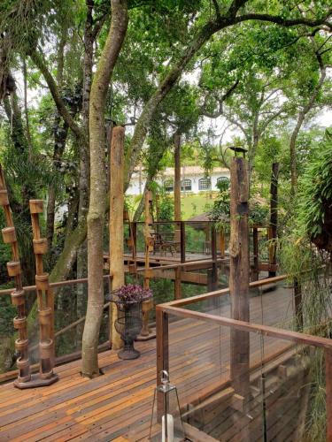 a wooden deck with trees and a fence at Confraria Colonial Hotel Boutique in Mairinque
