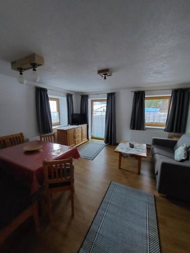 a living room with a table and a couch at Pension Appartementhaus Bergland in Biberwier