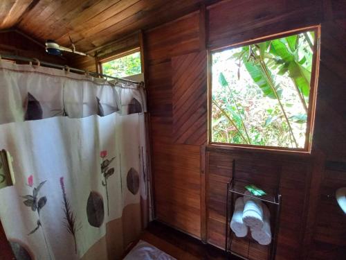 baño con cortina de ducha y ventana en Cabañas Los Laguitos Rio Celeste en El Achiote