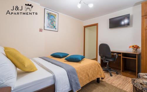 a bedroom with a bed and a desk with a computer at J&J Apartments, Szeroka 25 Apartament 13 in Toruń
