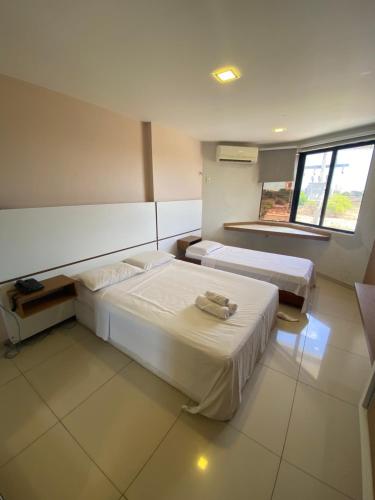 a room with two beds and a window at Flat - Victory Intermares in Cabedelo