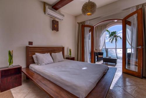 a bedroom with a large bed with a large window at Hotel Alcazar in San Juan del Sur