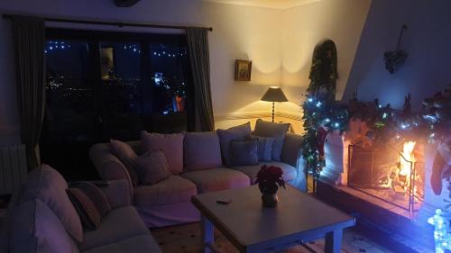 a living room with a couch and a fireplace with christmas lights at Domaine du Bois d'Amont in Cabris