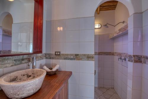 a bathroom with a stone sink and a shower at Hotel Alcazar in San Juan del Sur