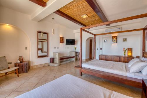 a bedroom with a large bed and a bathroom at Hotel Alcazar in San Juan del Sur