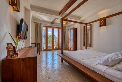 a bedroom with a bed and a television in it at Hotel Alcazar in San Juan del Sur
