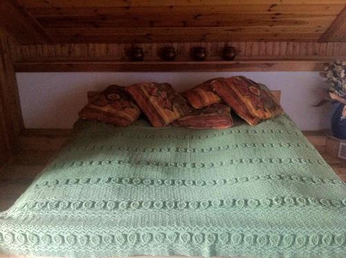 ein Bett mit einer grünen Decke mit Brot drauf in der Unterkunft Bea Hive in Ostrzyce