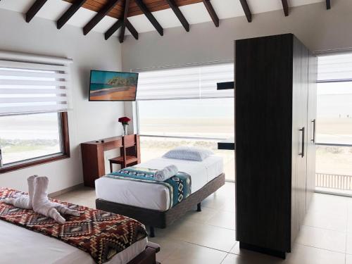a bedroom with two beds and a window at La Bocana de Quiximies Hotel in Cojimíes