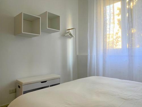 een witte slaapkamer met een bed en een raam bij Vivapartments MilanoSanSiro in Milaan