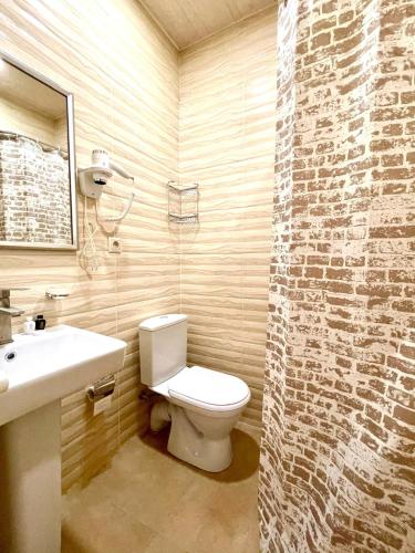 a bathroom with a white toilet and a sink at Glendale Boutique Hotel in Yerevan