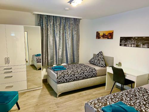 a room with two beds and a desk and a bed at Big Und Nice 3 Bedrooms in Hannover