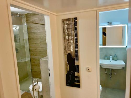 a bathroom with a guitar on the wall next to a sink at Big Und Nice 3 Bedrooms in Hannover