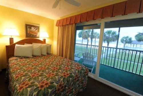 ein Hotelzimmer mit einem Bett und einem großen Fenster in der Unterkunft Destin Holiday Beach Resort in Destin
