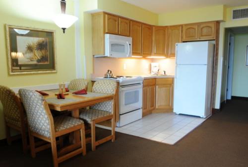 a kitchen with a table and a white refrigerator at Destin Holiday Beach Resort in Destin