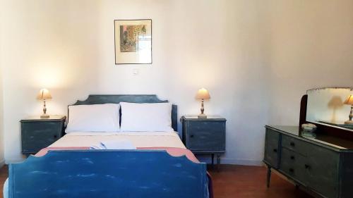 1 dormitorio con 1 cama azul y 2 mesitas de noche en thomais house corfu en Corfú
