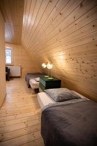 a room with two beds and a wooden ceiling at Rakouská vila in Bělá pod Pradědem