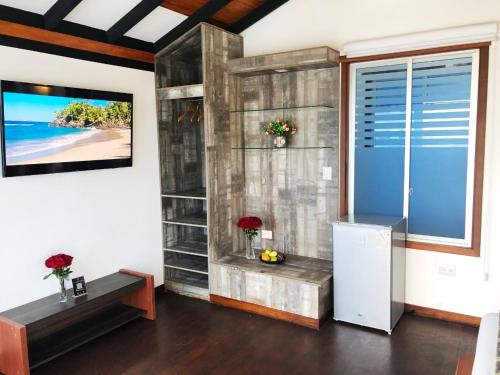 a living room with a large window and a refrigerator at La Bocana de Quiximies Hotel in Cojimíes