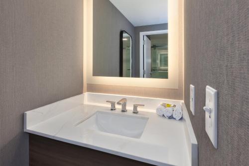 a bathroom with a white sink and a mirror at Staybridge Suites Pittsburgh Airport by IHG in Pittsburgh