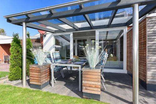 pérgola en un patio con mesa y sillas en Ferienhaus Inga, en Bensersiel