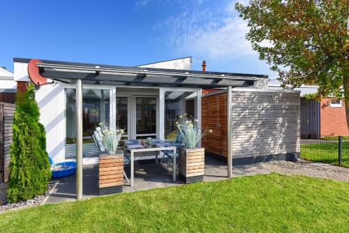 eine Pergola mit einem Tisch im Garten in der Unterkunft Ferienhaus Inga in Bensersiel