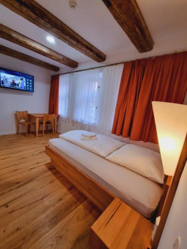 a bedroom with a bed with a lamp and a table at La Rustica Altstadthotel in Wernigerode