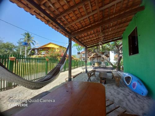 a porch with a hammock and a house at Algodoal Casa Verde in Maracanã