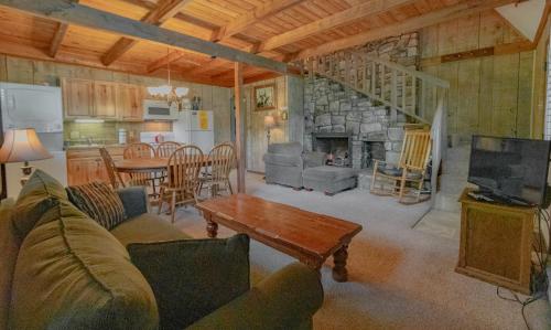 a living room with a couch and a table and a kitchen at Swiss Mountain Village in Blowing Rock