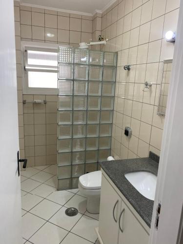 a bathroom with a toilet and a sink at Cobertura Guarujá Apto com Jacuzzi e Churrasqueira in Guarujá