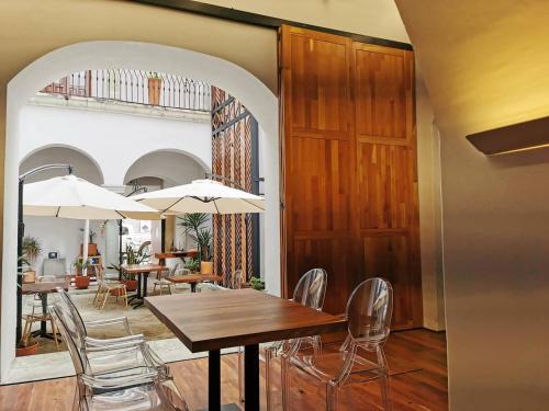 a dining room with a table and chairs with umbrellas at Casa de la Asunción in Oaxaca City