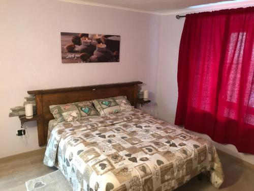 1 dormitorio con cama y cortina roja en La Maison du Gorret, en Aosta