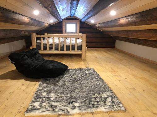 a attic room with a bed and a rug at Mini-Mooh cabin in Clearwater