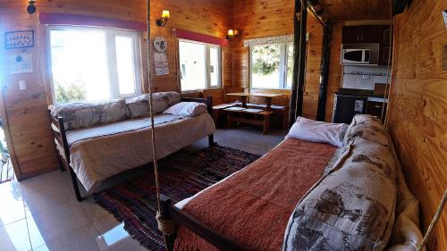 a room with a bed and a couch in a cabin at Cabañas Sol de Aucar in Quemchi