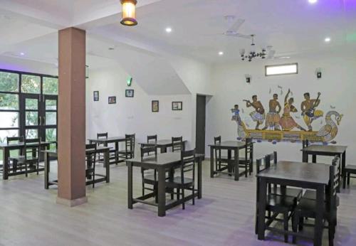 una sala da pranzo con tavoli e sedie di Hotel Ramayana Khajuraho a Khajurāho