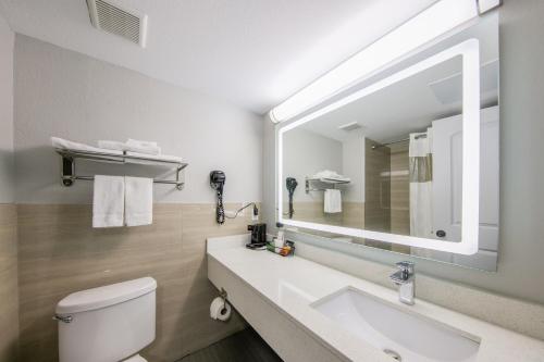 a bathroom with a sink and a mirror at Americas Best Value Inn Brenham in Brenham