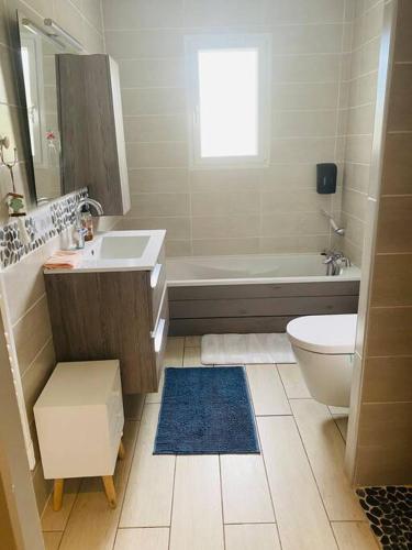 a bathroom with a sink and a toilet and a tub at Frenchy home☆ piscine ☆spa☆ bassin d’arcachon in Mios