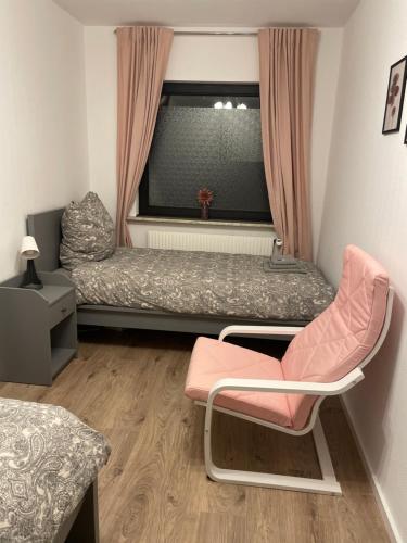 1 dormitorio con 1 cama, 1 silla y 1 ventana en Schöne Unterkunft mit kostenlosen Parkplatz., en Buchholz in der Nordheide