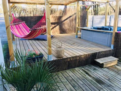 a hammock on a deck with a gazebo at Frenchy home☆ piscine ☆spa☆ bassin d’arcachon in Mios