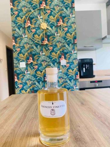 a bottle of whiskey sitting on a wooden table at Frenchy home☆ piscine ☆spa☆ bassin d’arcachon in Mios