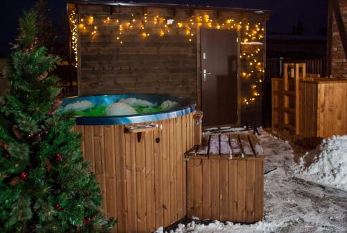 a hot tub in a yard with a christmas tree at Kaszubskie Zacisze in Władysławowo