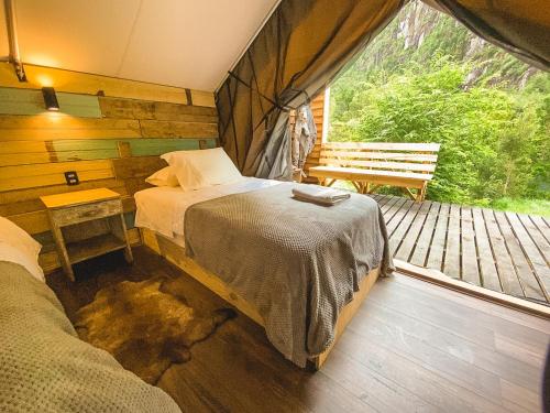 1 dormitorio con 1 cama y un banco en la terraza en Matapiojo Lodge, en Futaleufú