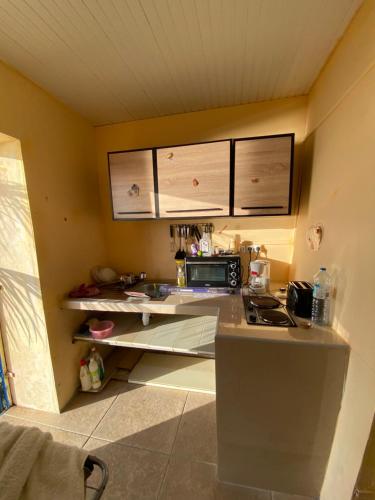 a small kitchen with a counter and a microwave at kolay chambre HOTE in Saint-Pierre